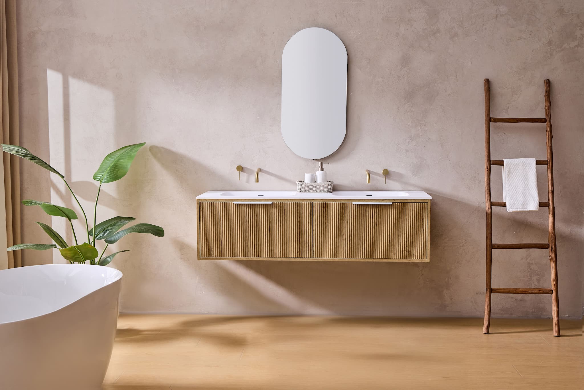 Modern bathroom with fluted wood grain vanity, double sinks, freestanding bath, plant, and ladder.