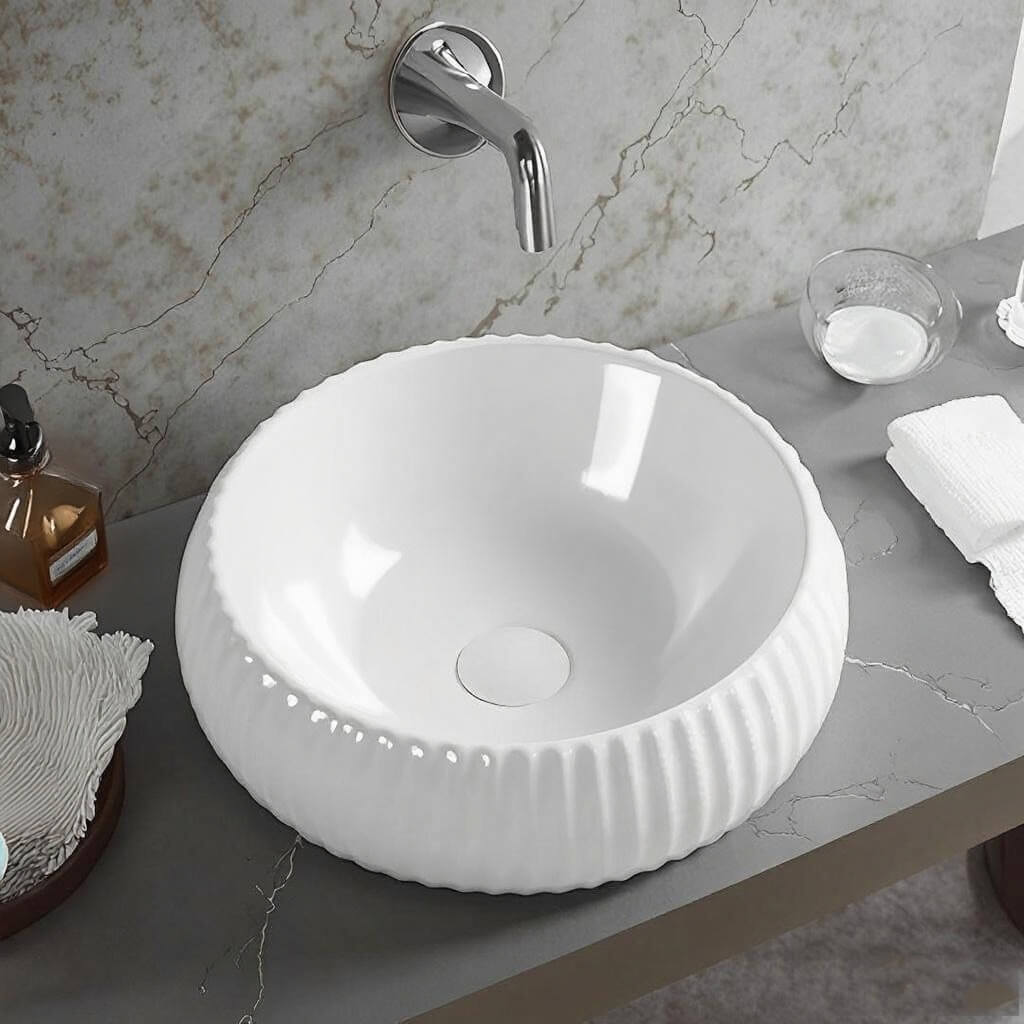 Lukka Oran Fine Ceramic Fluted Art Basin in round shape, 400×400×140 mm, Gloss White on a marble countertop with a silver faucet.