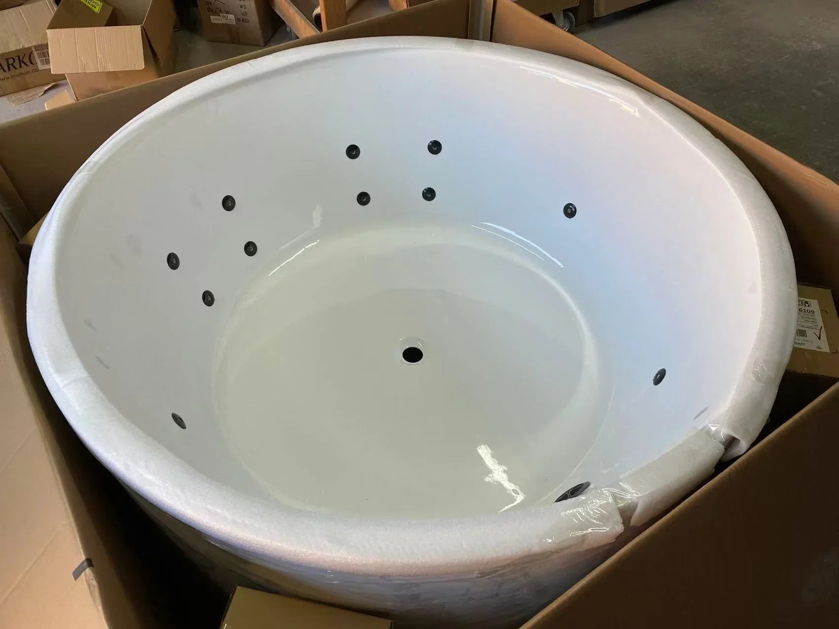 Round white freestanding spa bath in delivery packaging, Secasa Home bathroom renovation product