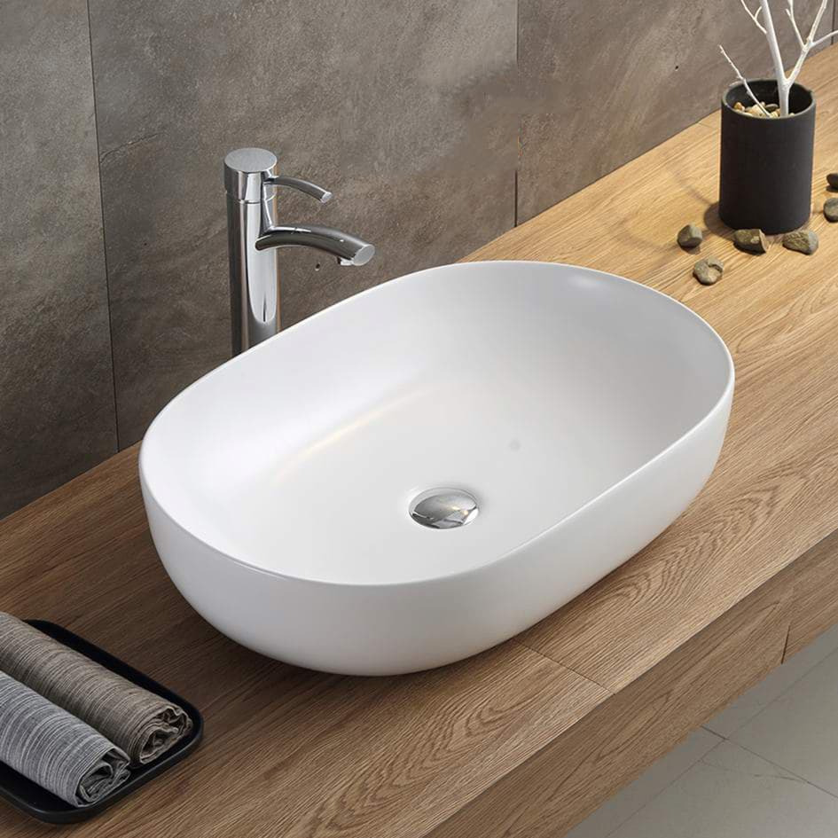 Lukka Ellips oval fine ceramic above counter basin (LK-ELA series) on a wooden countertop with a modern faucet.