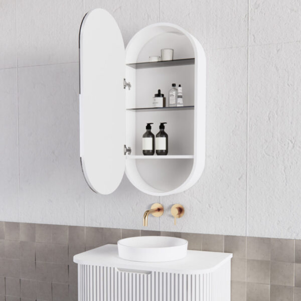 Modern oval white bathroom mirror cabinet open above vanity with gold tapware