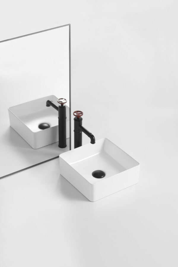 Modern square white bathroom vanity basin with matte black tapware, reflected in mirror