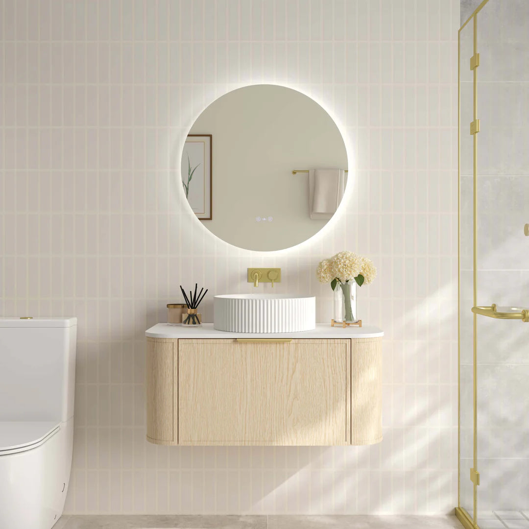 Mercio Elva 890mm Curved Wall-Hung Vanity in Natural Oak, featuring a single soft-close drawer and rounded edges, elegantly styled in a modern bathroom setting with a counter-top basin.