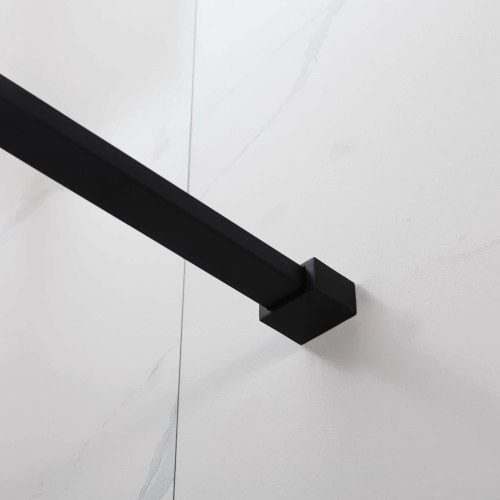 Black metal towel bar mounted on a white tiled wall