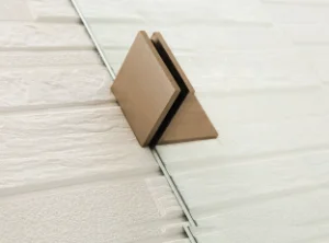 Brushed Bronze-colored corner protector on a tiled floor of Covey CVP007 shower panel