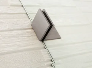 Metallic square object on a textured white surface