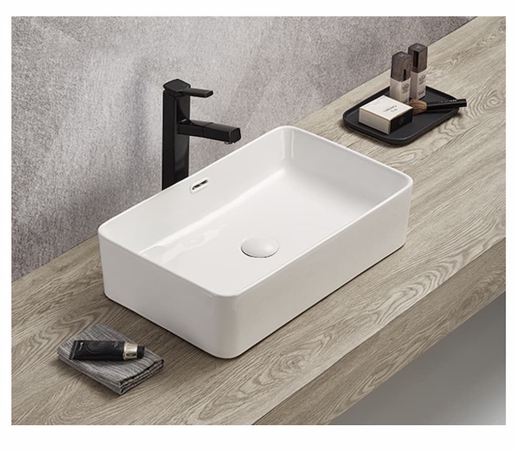 Lukka Crete 550mm rectangular fine ceramic above counter basin (LK-CA555-OF)  with black faucet on a wooden countertop