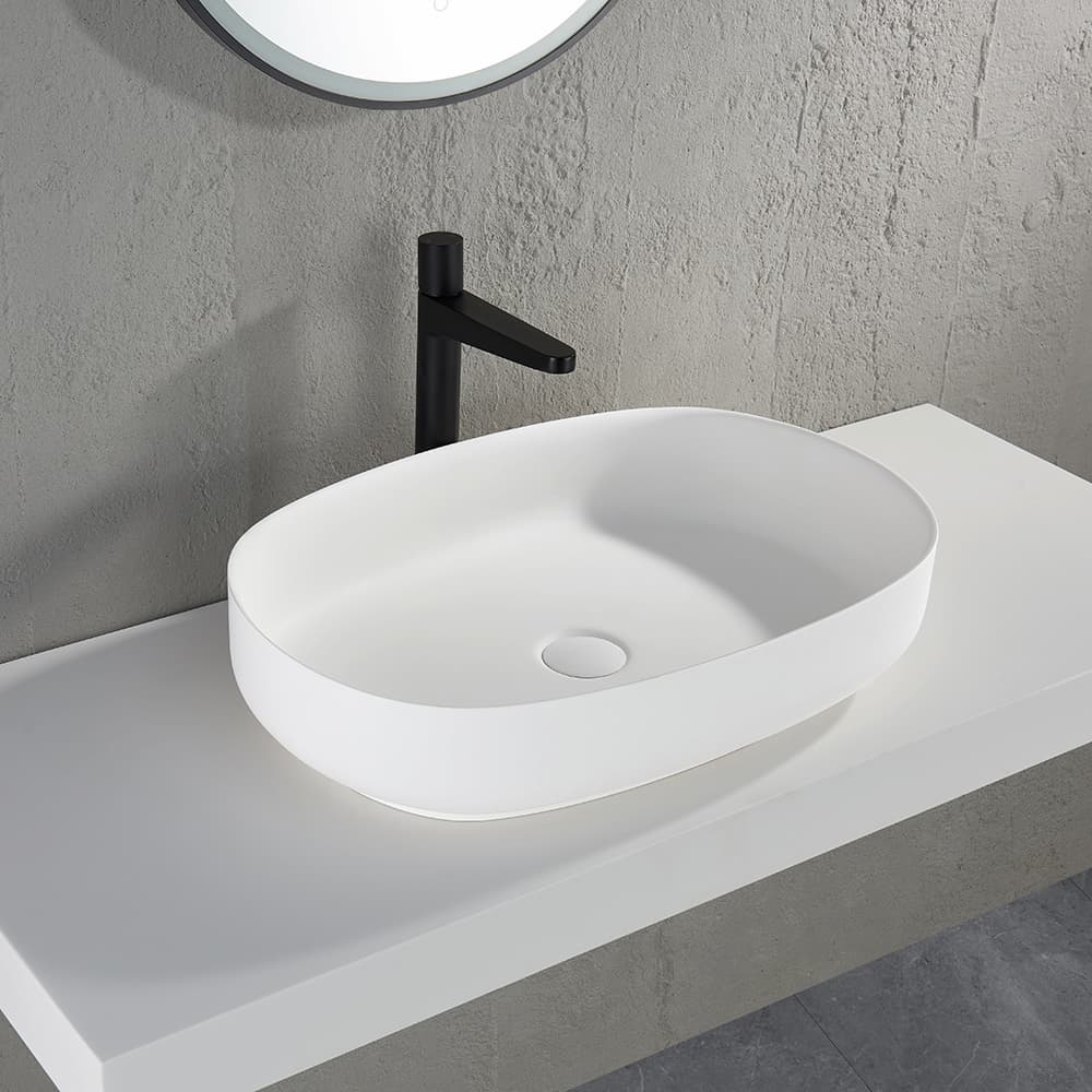 Ellips Solid Surface Above Counter Basin in Matte White installed on vanity top with black mixer tap
