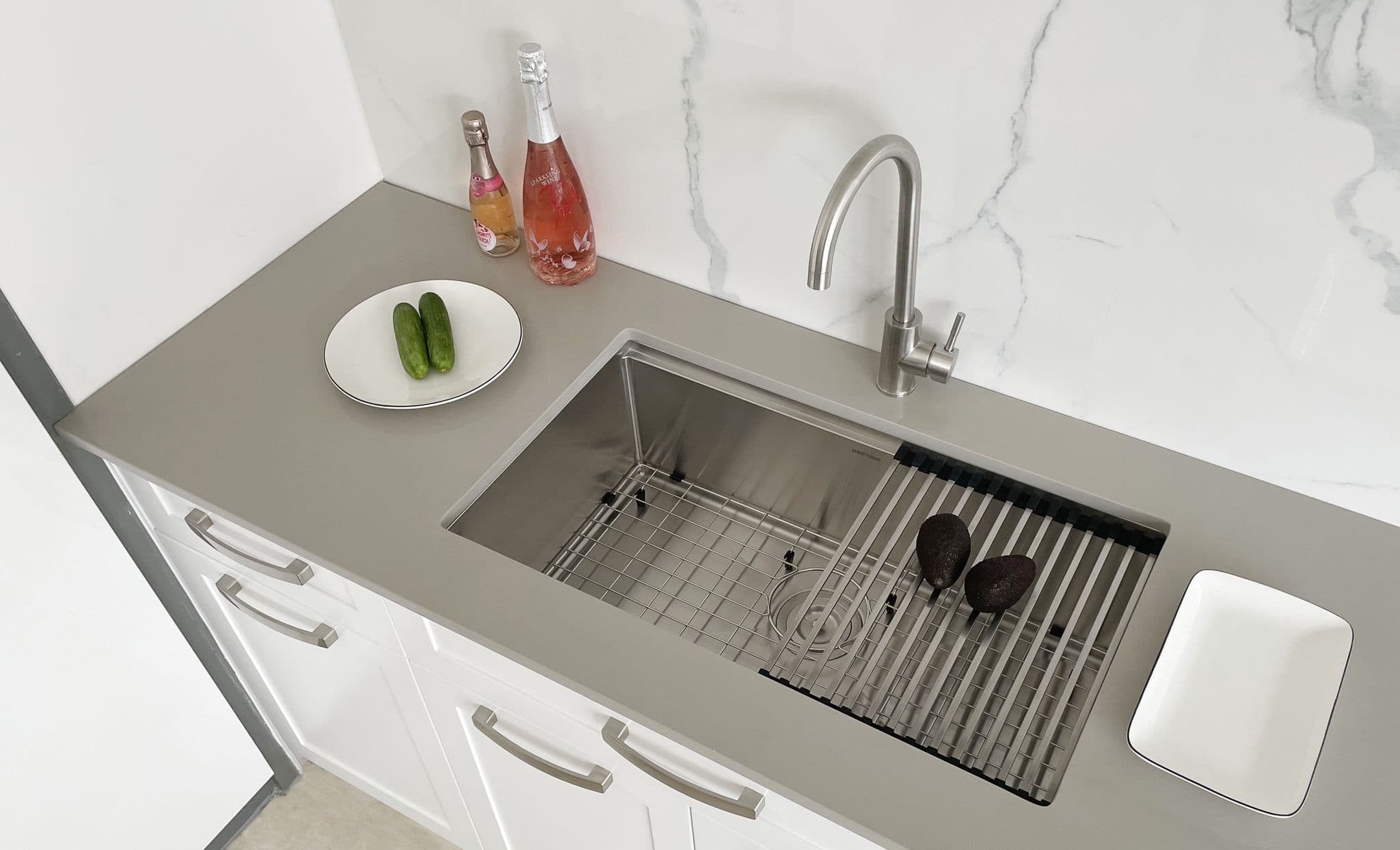 Lifestyle view of Kliff LK-SSK-810 handmade sink undermounted in a modern kitchen, featuring matching sink grid and roll-up dish rack.