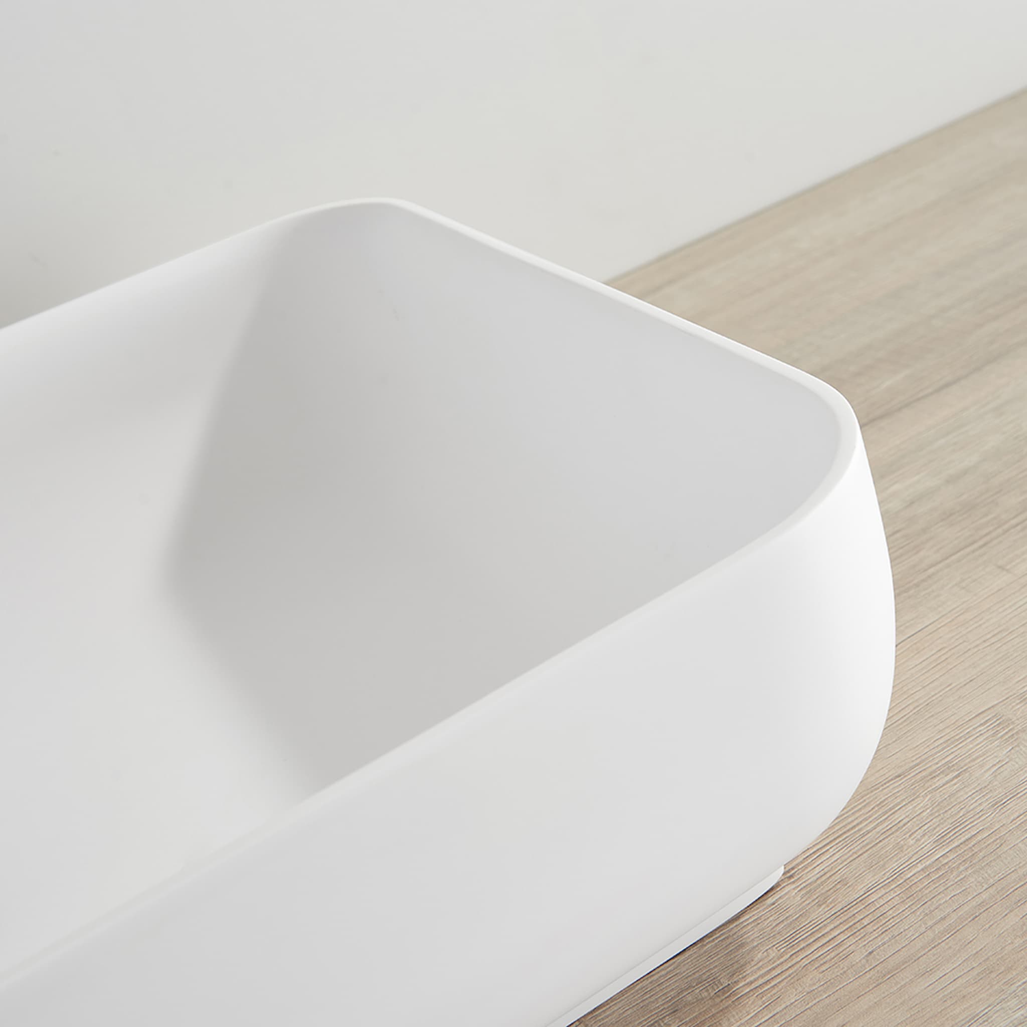 Kliff Solid Surface Above Counter Basin in Matte White finish White ceramic sink on a wooden floor
