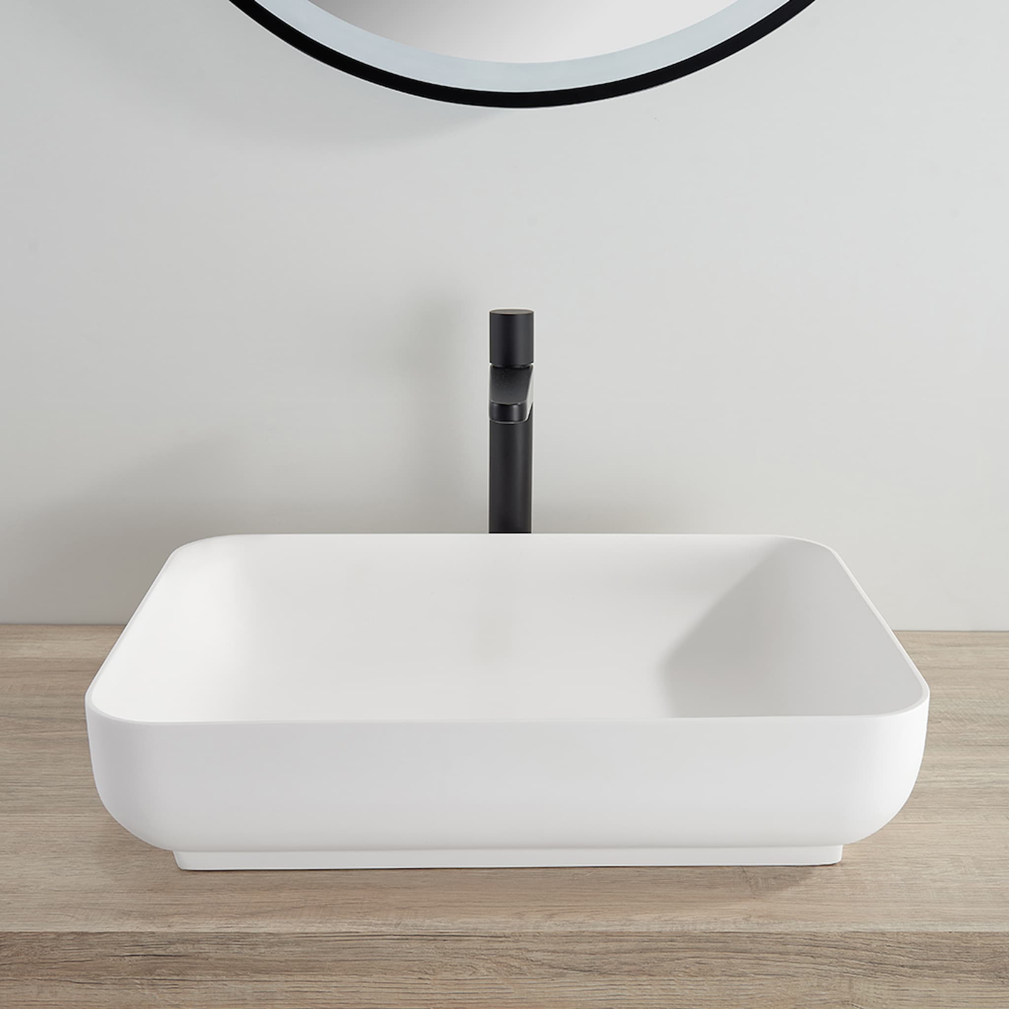 Kliff Solid Surface Above Counter Basin in Matte White finish White rectangular sink with black faucet on a wooden countertop