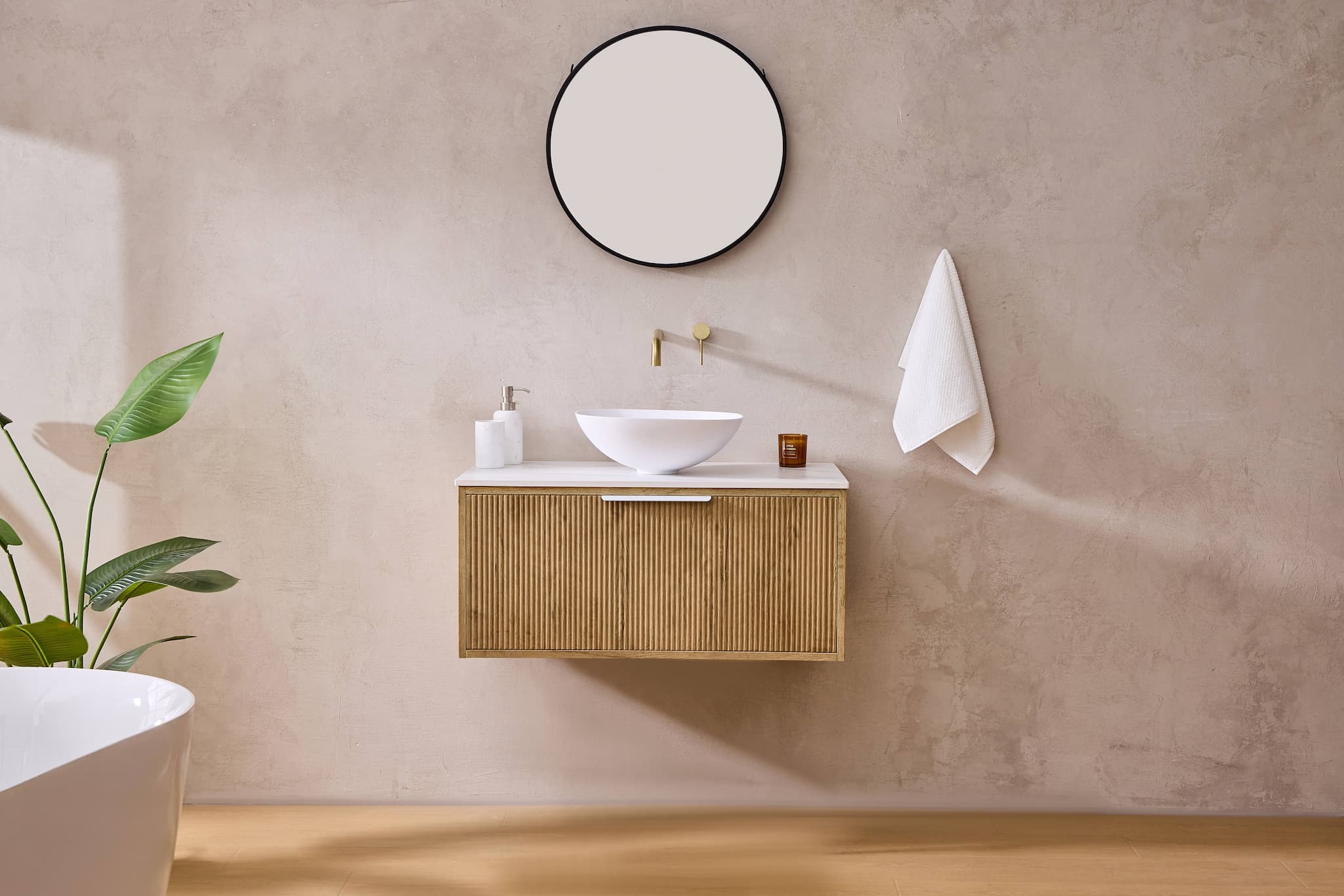 Modern bathroom with oak floating vanity, round mirror, vessel sink, and minimalist decor