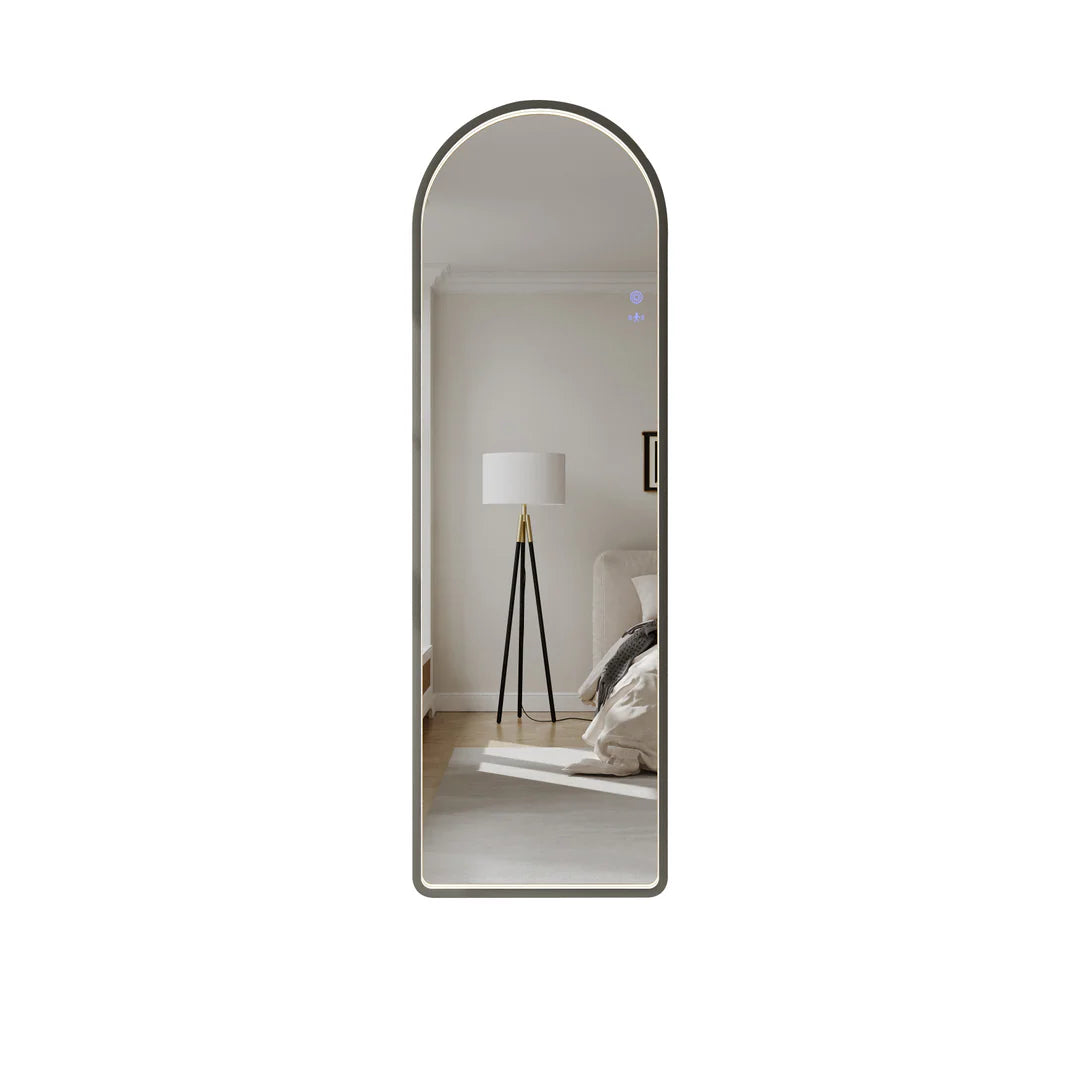 Arch LED bathroom mirror in gun metal finish reflecting modern bedroom with floor lamp