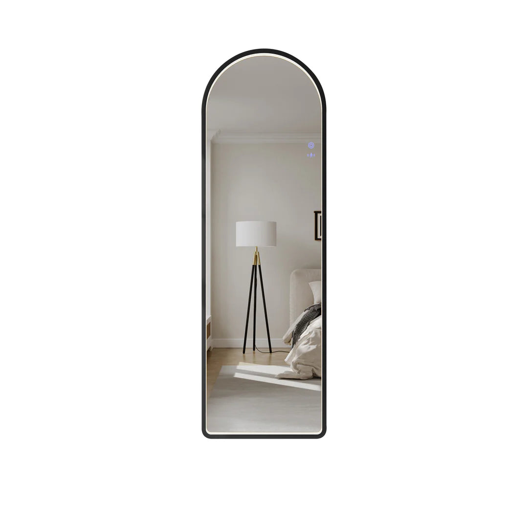 Tall arch LED bathroom mirror with matt black frame reflecting modern bedroom decor