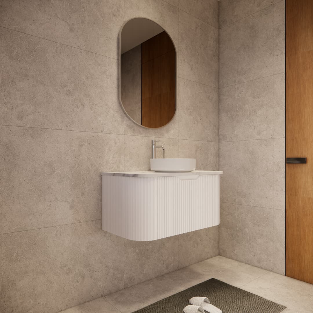 Modern bathroom with space-saving matte white curved vanity, round mirror, and stone tiles.